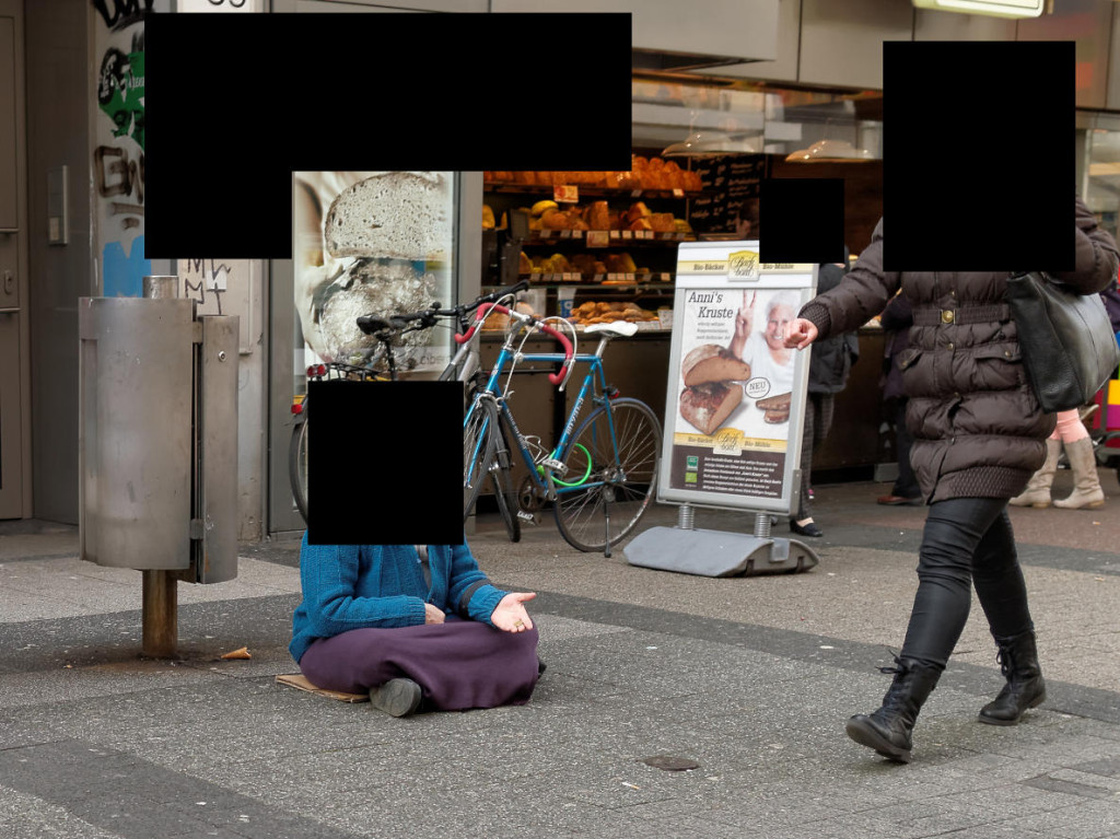 Straßenfotografie: Passantin ignoriert Bettlerin. - Afgrund der Rechtslage in Deutschland muss das Bild bis zur Unkenntlichkeit zensiert werden.